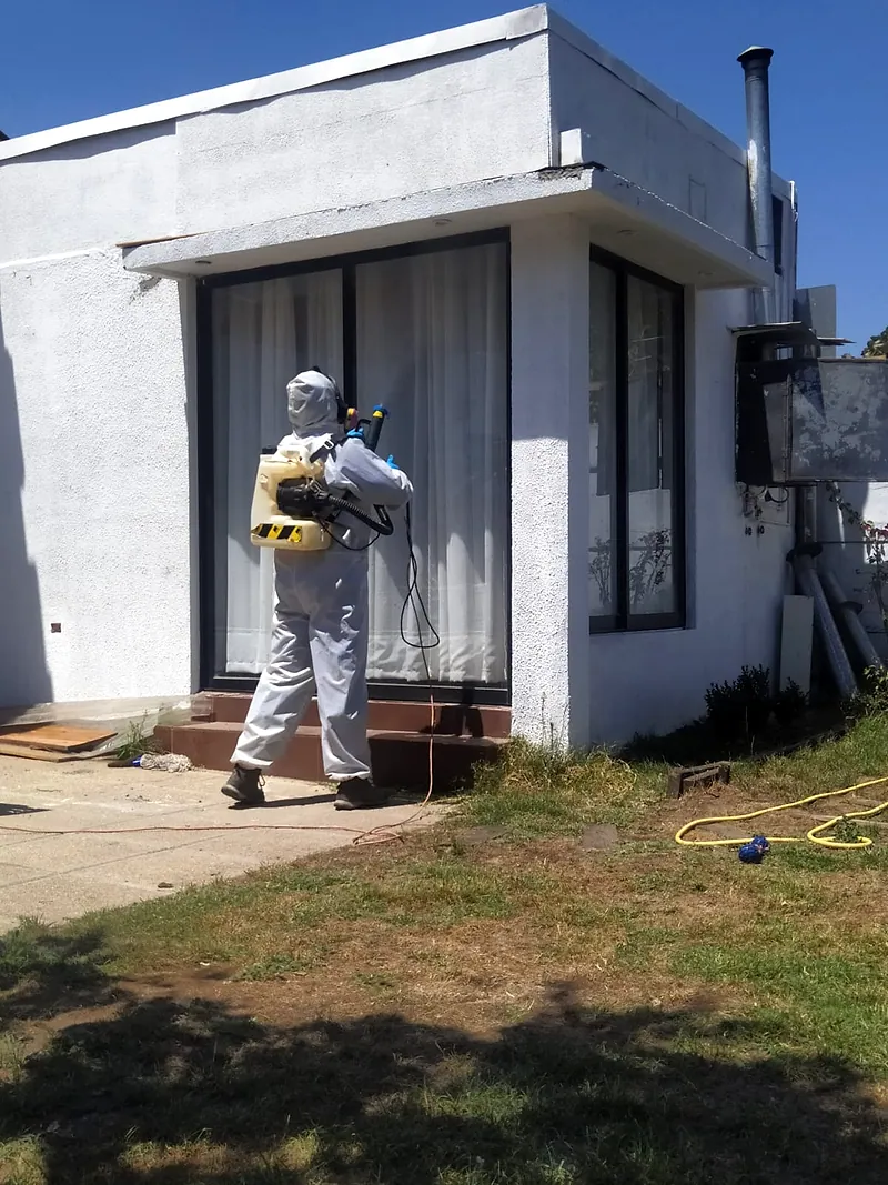 Aplicación de barrera química en el perímetro exterior de una casa