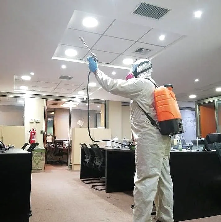 Técnico de B&C aplicando con equipo de mochila en las instalaciones de una empresa